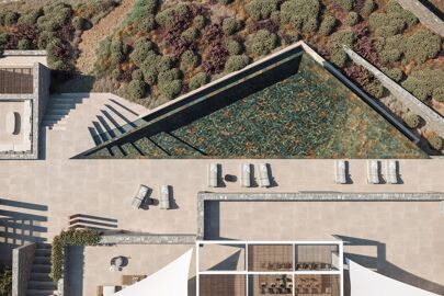 Aerial view of Blue Sky's infinity pool and the forest in the distance with lounge chairs laid about