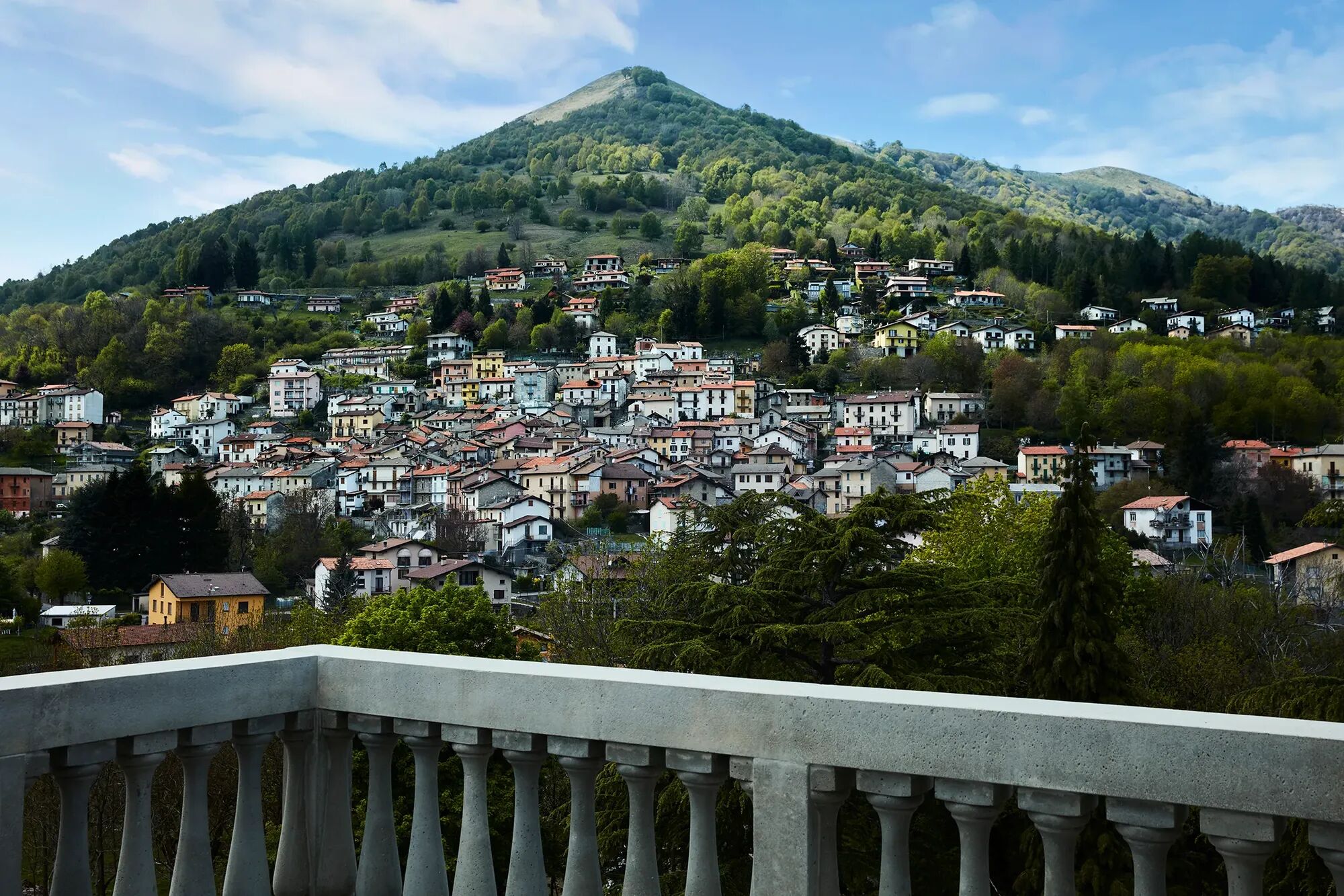 A view from Lake Como of a beautiful mountain and luxury homes in the forefront