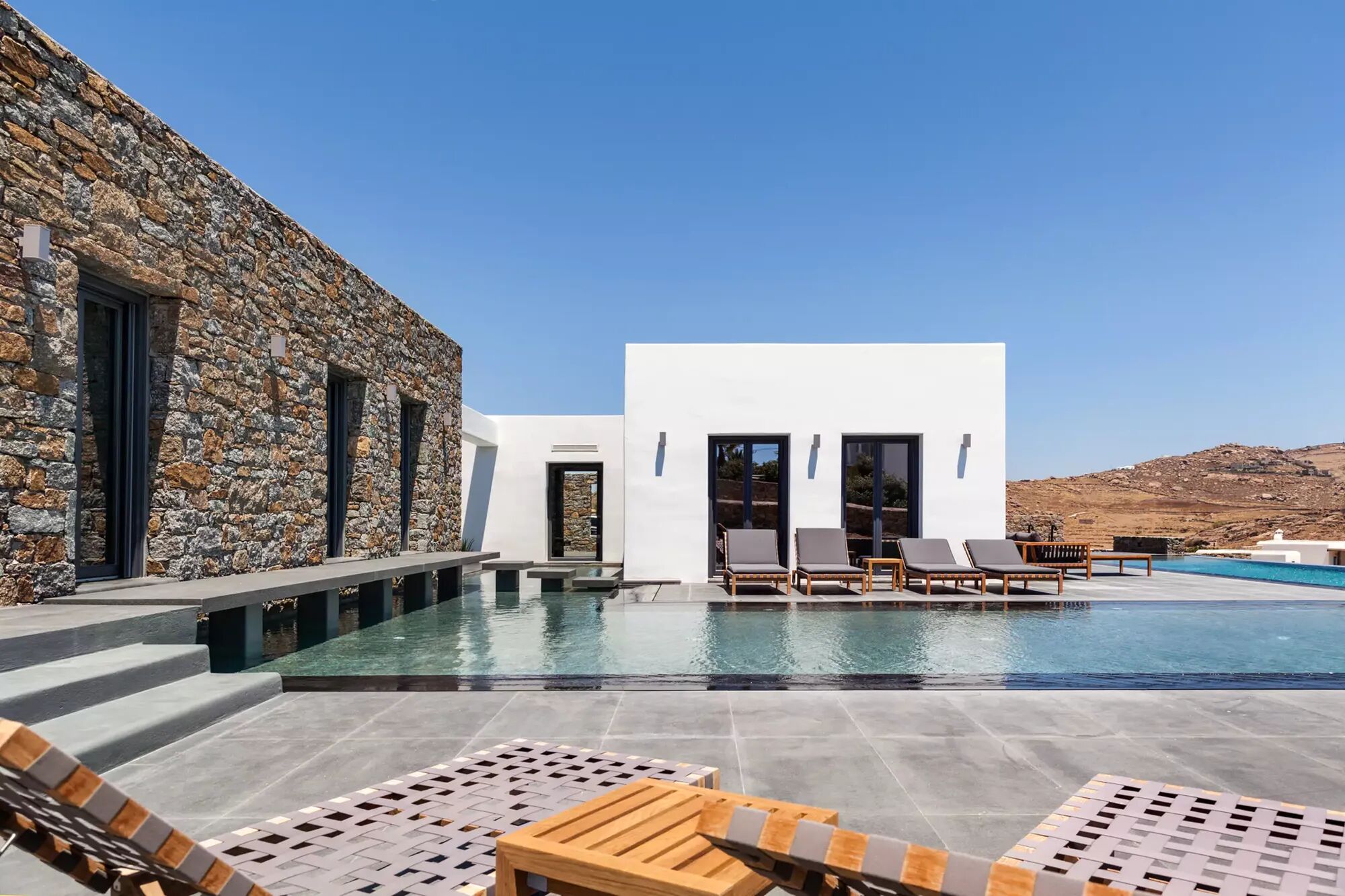 The sunloungers and modern pool outside Villa Manifica in Mykonos