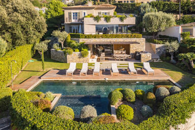 Elegant Villa Emerald in Cannes with terraced design, manicured gardens, and a heated pool surrounded by sun loungers and lush greenery
