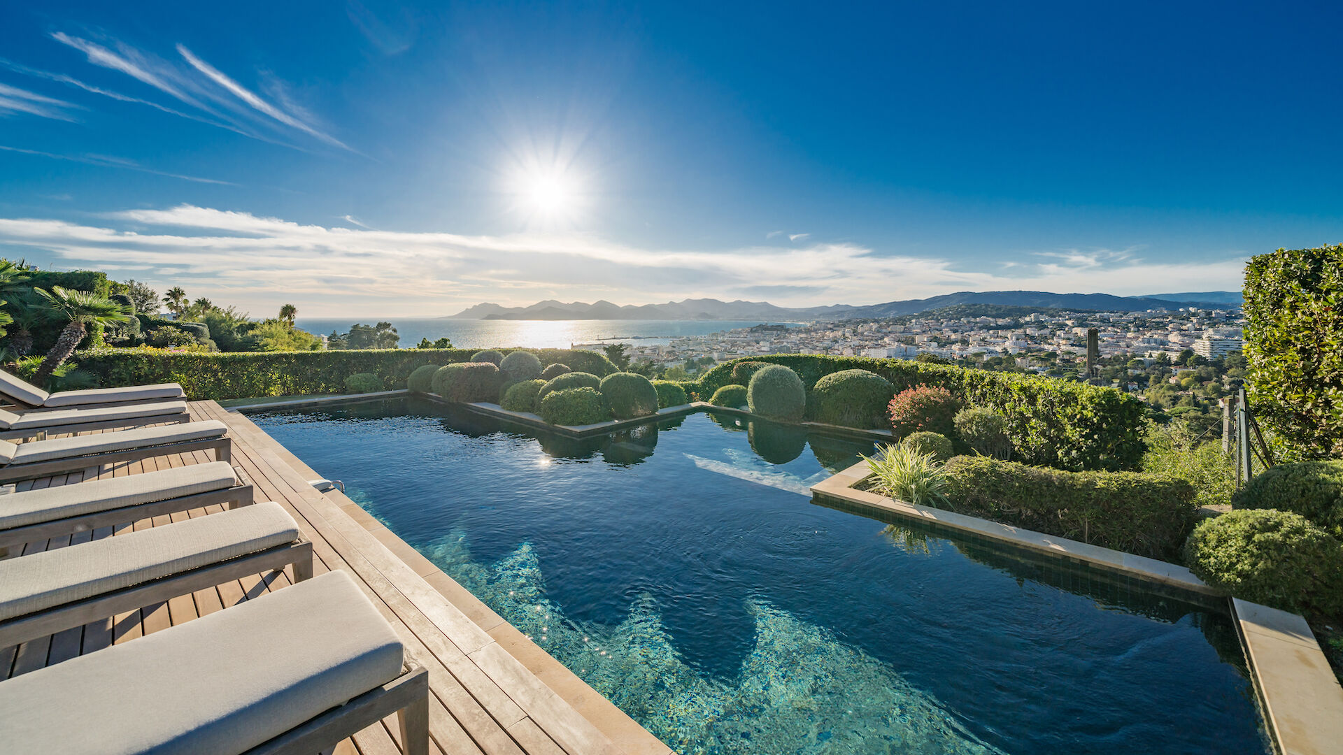 Infinity-edge pool at Villa Emerald overlooking Cannes Bay, with panoramic Mediterranean views and sculpted landscaping