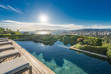 Infinity-edge pool at Villa Emerald overlooking Cannes Bay, with panoramic Mediterranean views and sculpted landscaping
