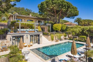 Poolside view of Villa Emma showing Provencal architecture, multiple outdoor living areas, and panoramic greenery near Cannes