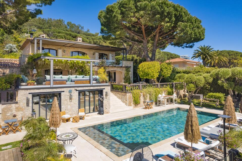 Poolside view of Villa Emma showing Provencal architecture, multiple outdoor living areas, and panoramic greenery near Cannes