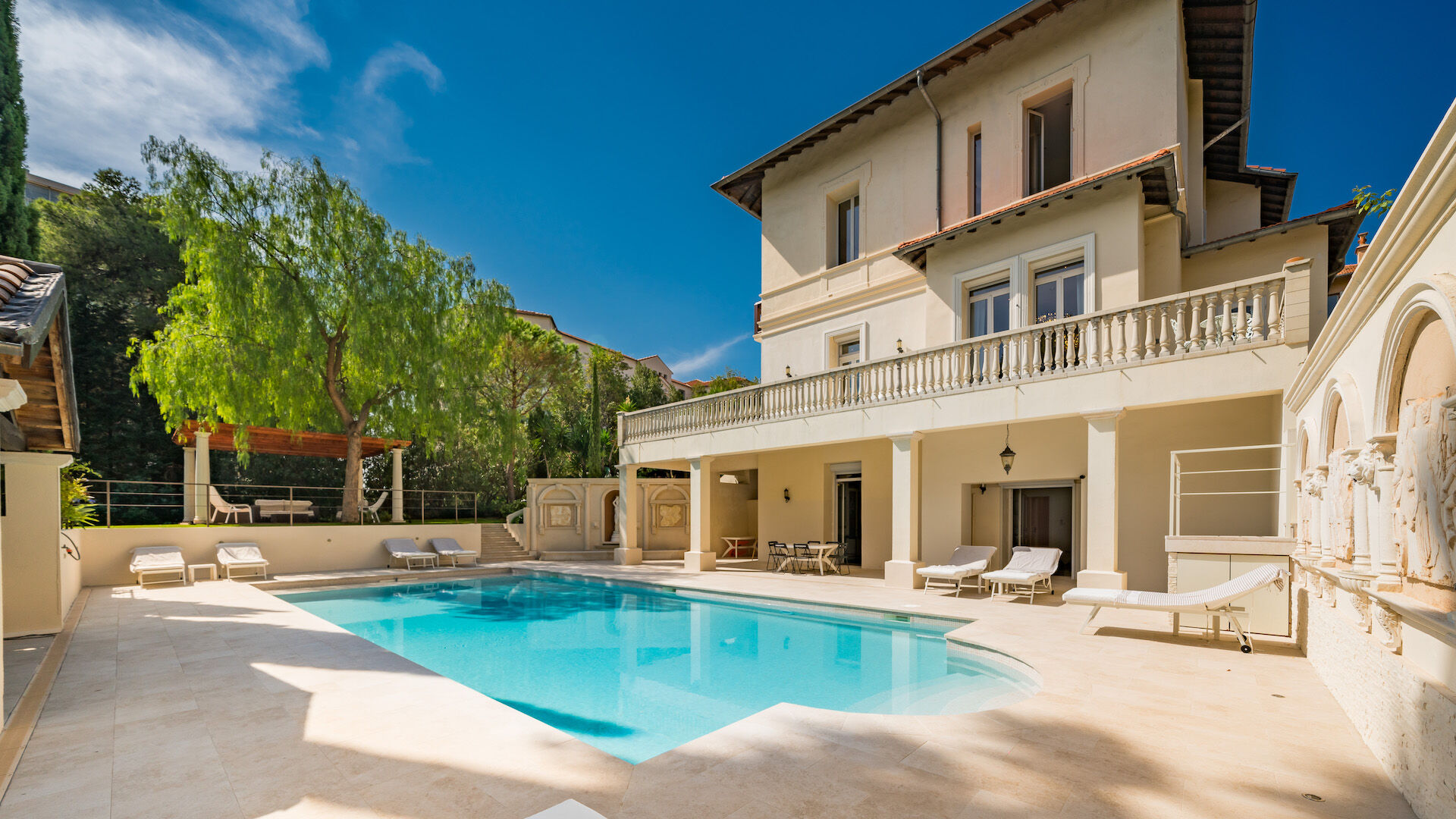 Sunlit terrace and heated saltwater pool at Villa Iris, a luxury villa rental in Cannes with shaded lounging and outdoor dining areas