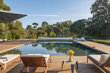 Heated outdoor pool at Villa Paradis with serene deck loungers and lush forest surroundings, ideal for luxury escapes near Cannes