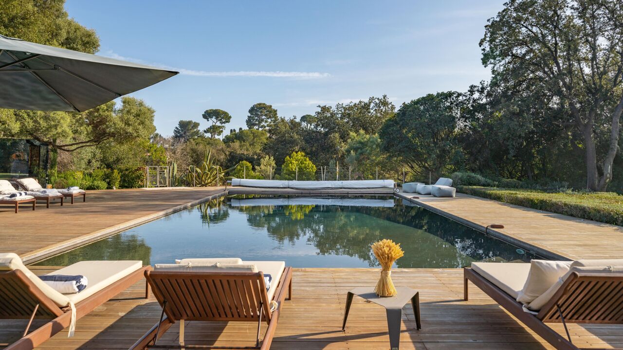 Heated outdoor pool at Villa Paradis with serene deck loungers and lush forest surroundings, ideal for luxury escapes near Cannes