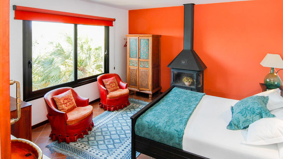One of the large bedrooms in Can Bab in Ibiza with a beautiful view and plush chairs to relax in