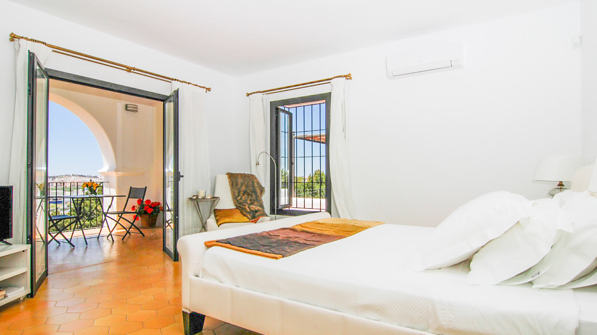 One of the large bedrooms in luxury rental Can Bab with patio doors into a beautiful balcony
