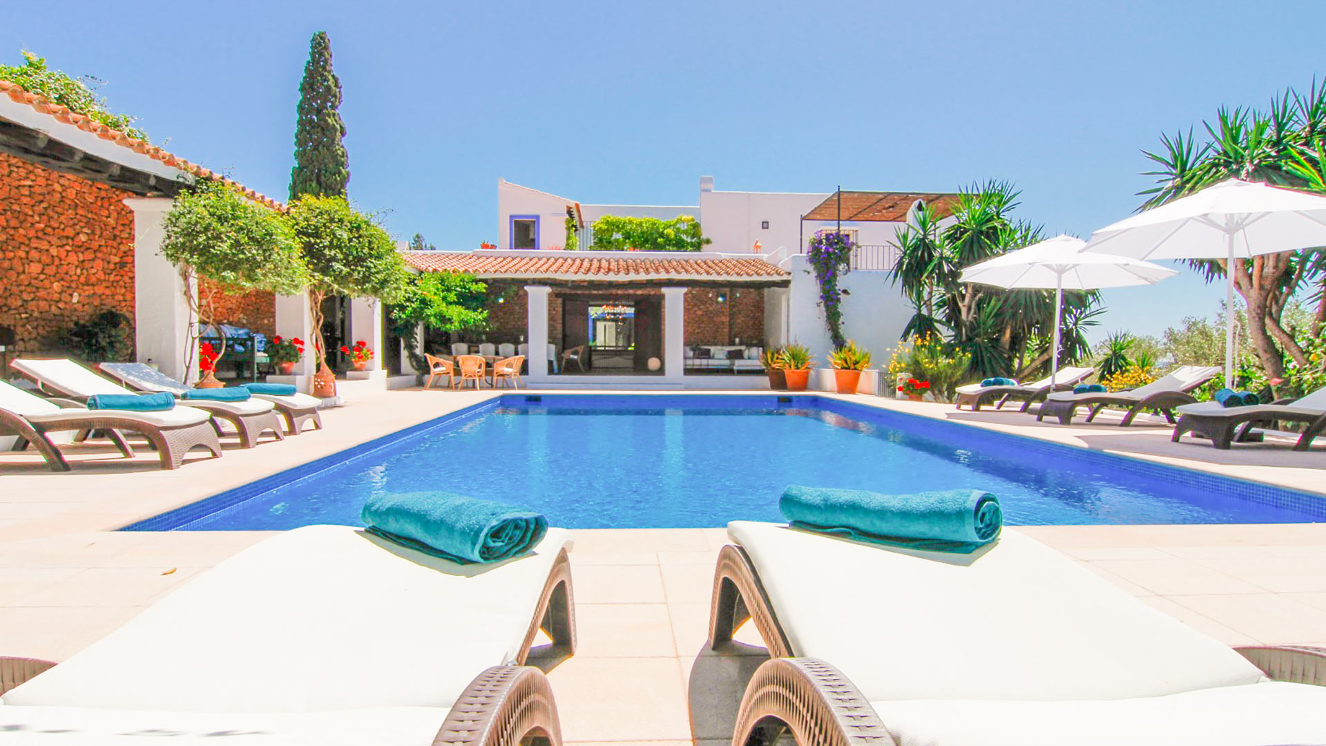 Swimming pool view at Can Bab in Ibiza headed by the pergola