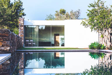 Villa Can Basso in Ibiza's swimming pool and the a view into the living space from outside