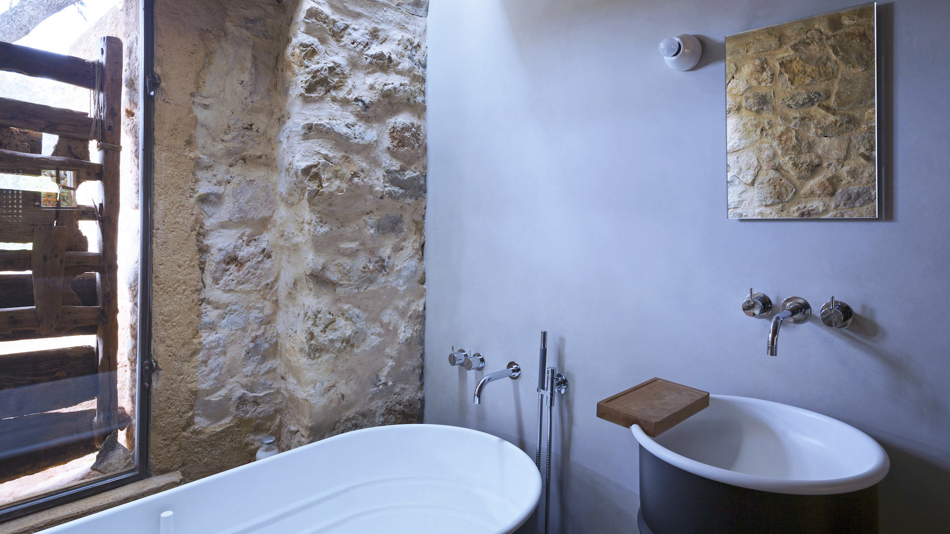 The stylish bathtub and basin and stone walls at Villa Can Basso in Ibiza