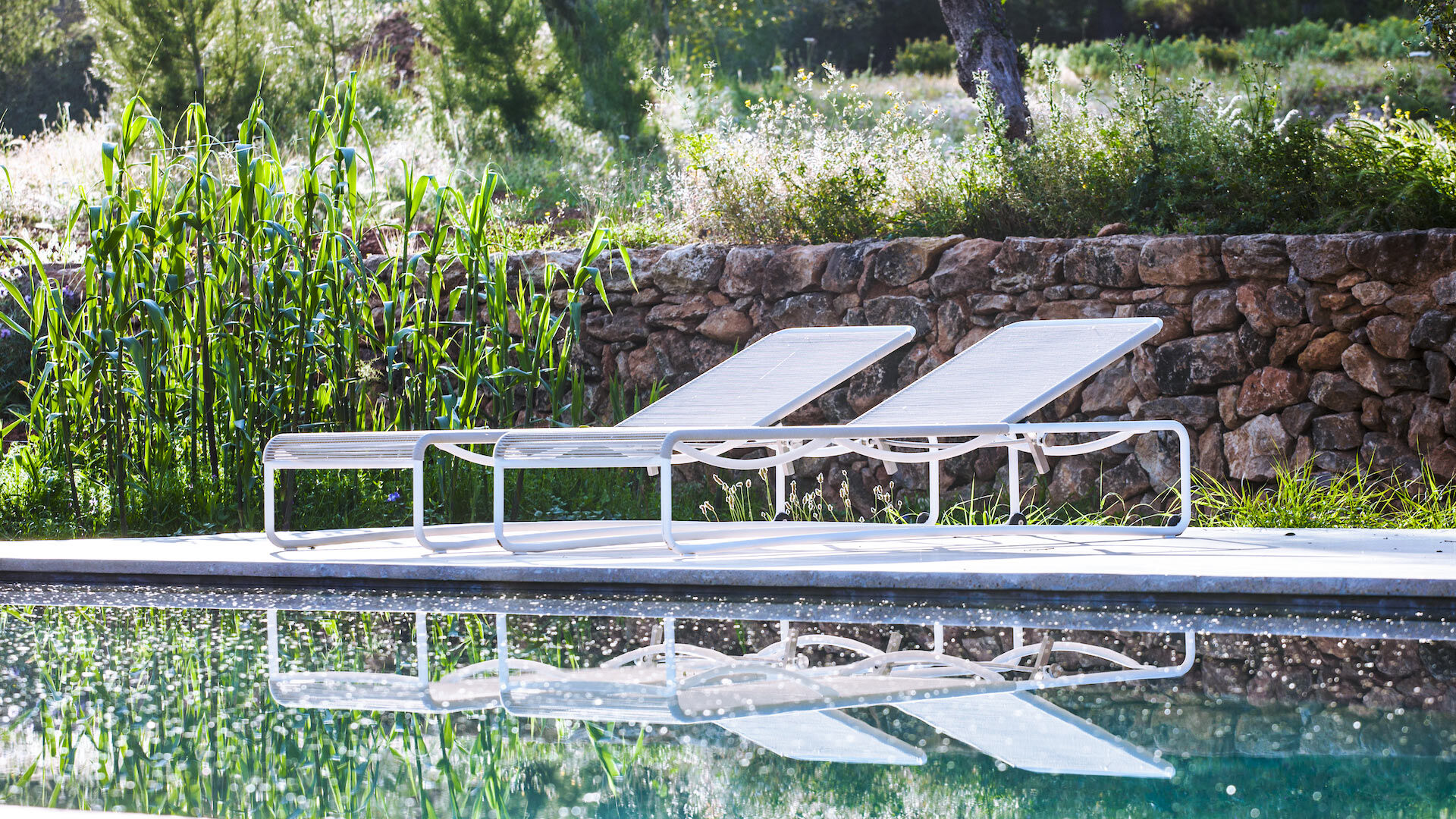 Sunloungers next to the beautiful pool in the serene Villa Can Basso in Ibiza