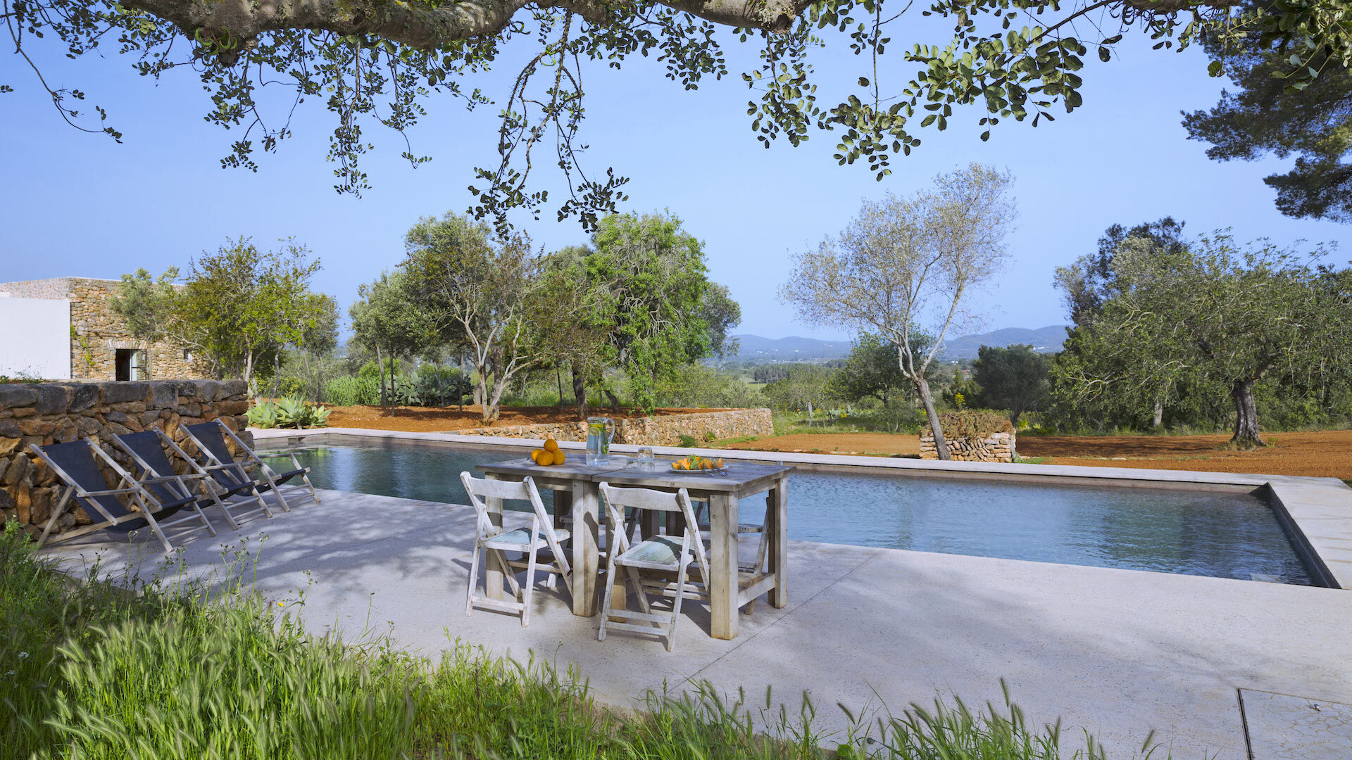 A moment of peace with a small dining table poolside at Villa Can Basso in Ibiza