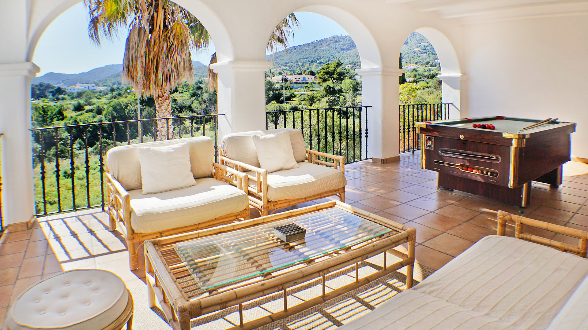 Shaded balcony with seating and pool at the luxury villa rental Can Selena in Ibiza