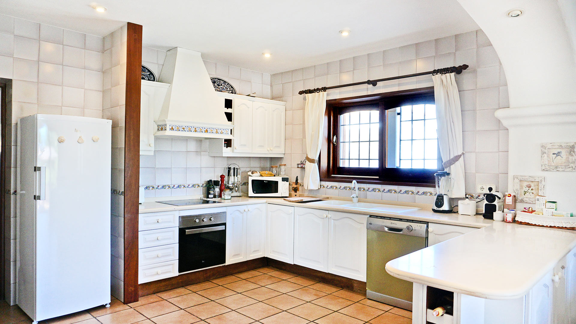 The beautiful white kitchen with modern appliances in the luxury villa rental Can Selena in Ibiza