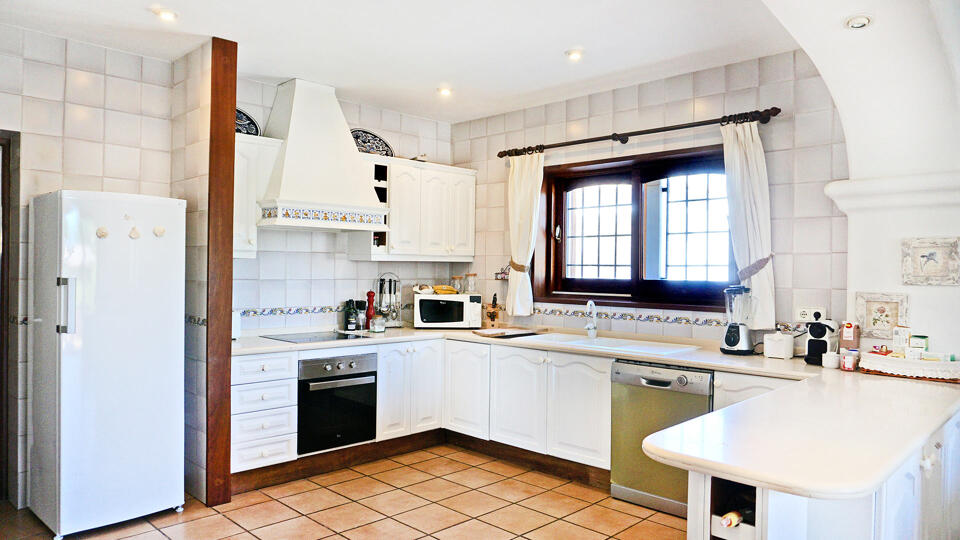 The beautiful white kitchen with modern appliances in the luxury villa rental Can Selena in Ibiza