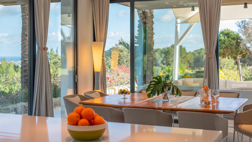 The dining area with floor to ceiling windows showcasing the best of Ibiza from Villa Casa Isa