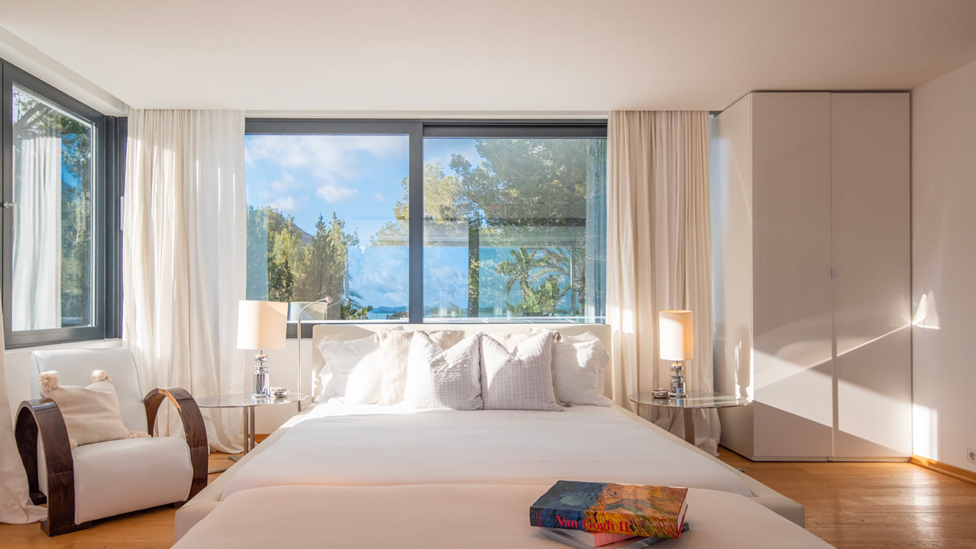 Comfortable seating and a large bed with sunlight spilling into one of the bedrooms at Villa Casa Isa in Ibiza