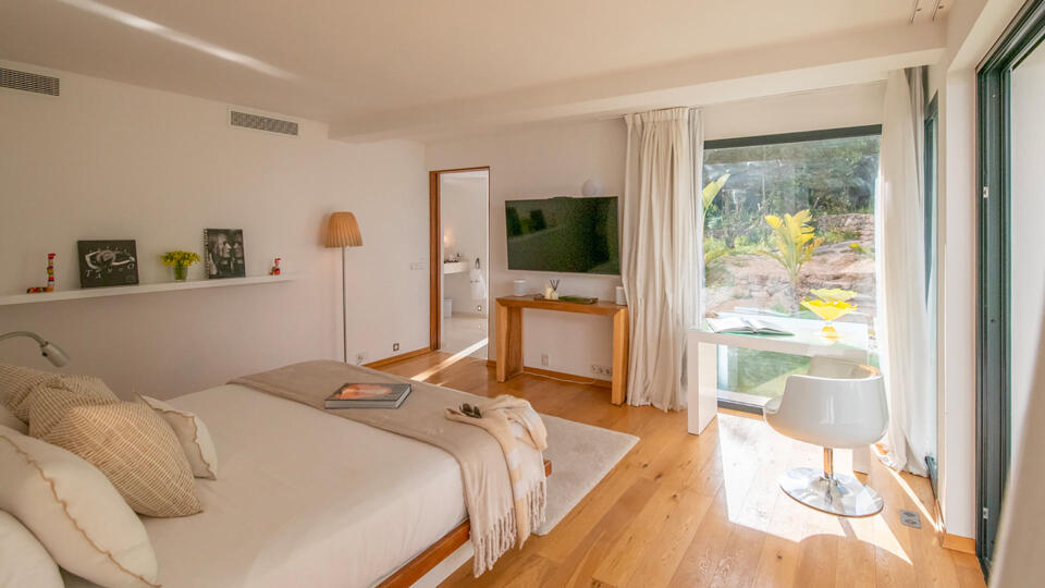 One of the large bedrooms in Villa Casa Isa in Ibiza with big large windows with beautiful sunlight streaming in