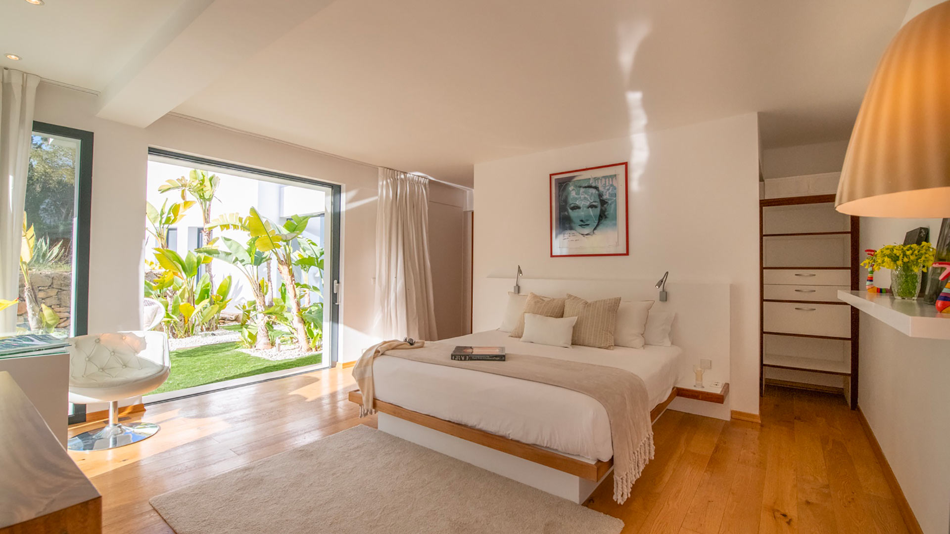 The patio doors wide open in one of the bedrooms at Villa Casa Isa in Ibiza with soft white furnishings