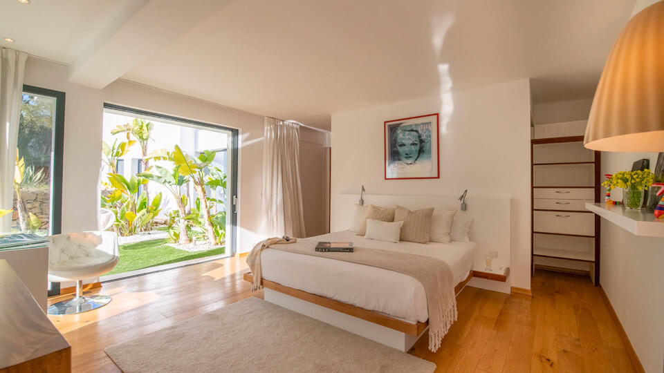 The patio doors wide open in one of the bedrooms at Villa Casa Isa in Ibiza with soft white furnishings