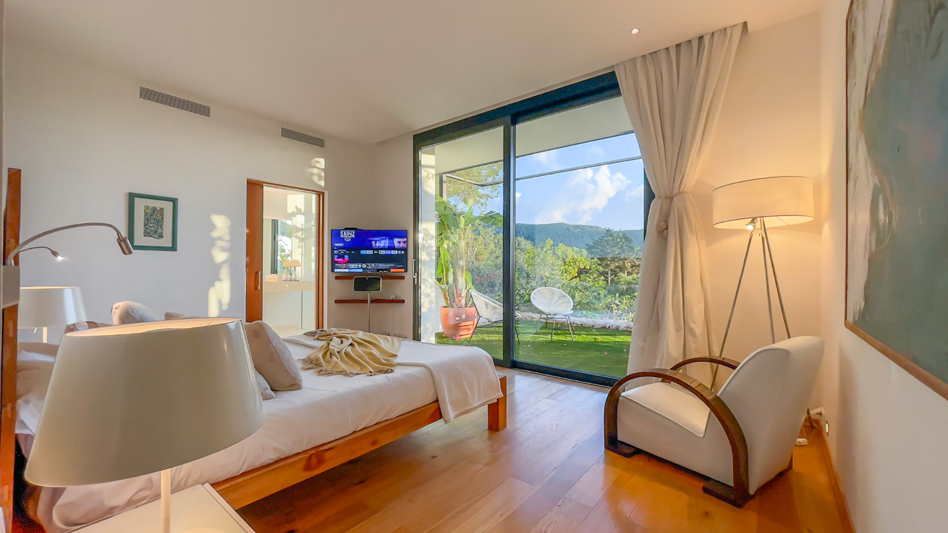 Large bedroom with patio access to the gardens and view of the hills of Ibiza at Villa Casa Isa