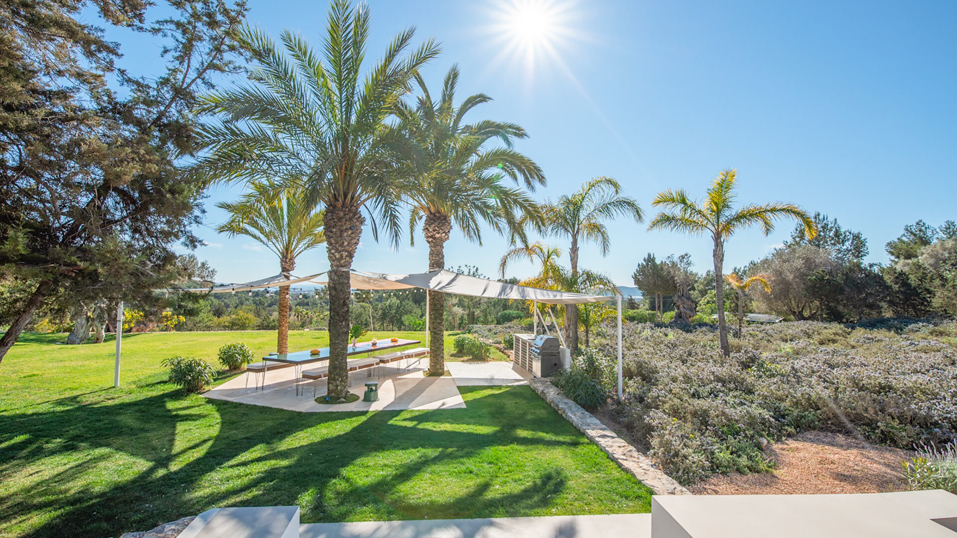 Well maintained gardens in Villa Casa Isa in Ibiza with beautiful palm trees adorning it