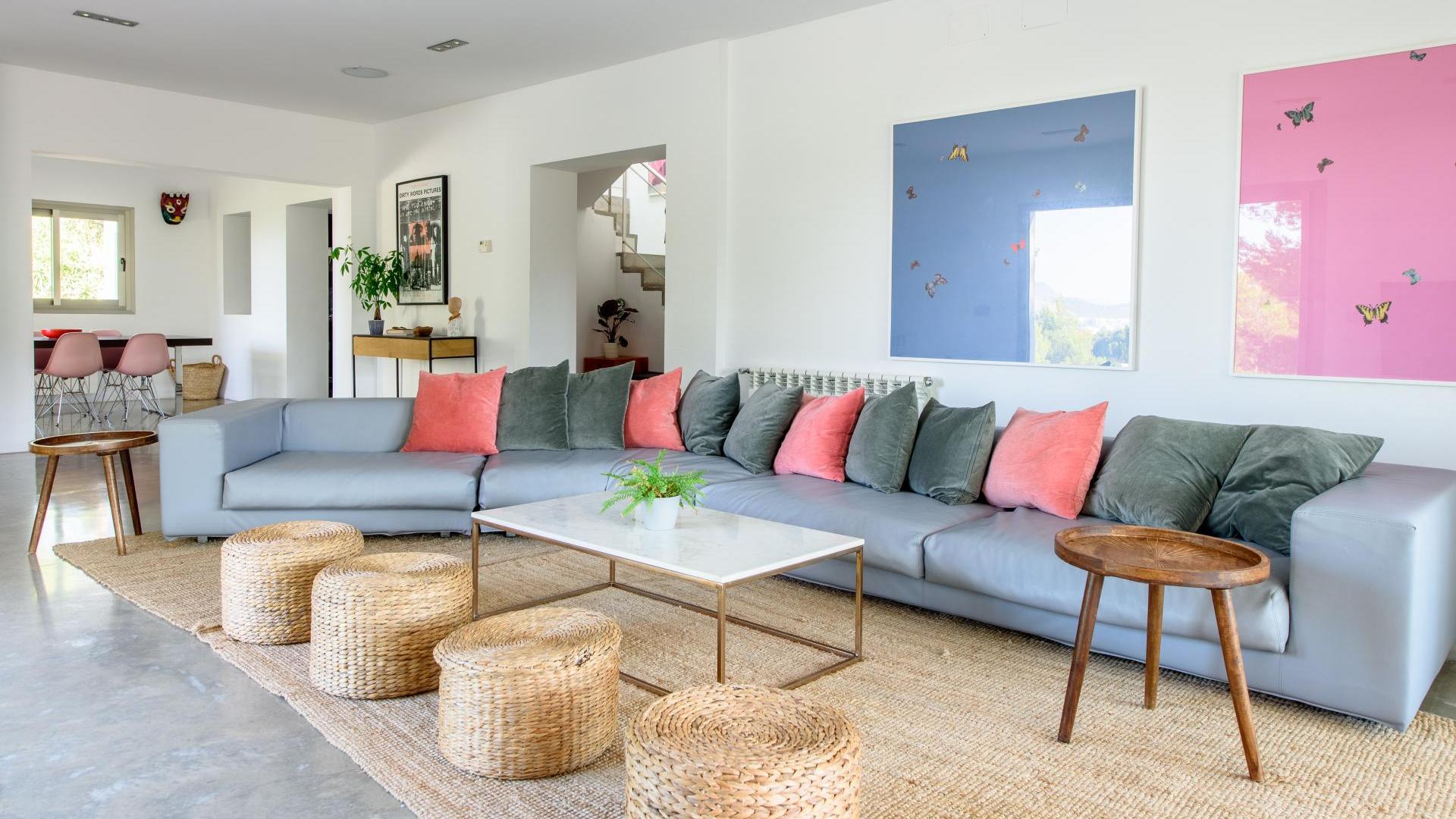 Lounging area at Villa Fabrik with an extra long sofa and incredible blue and pink artwork in Ibiza
