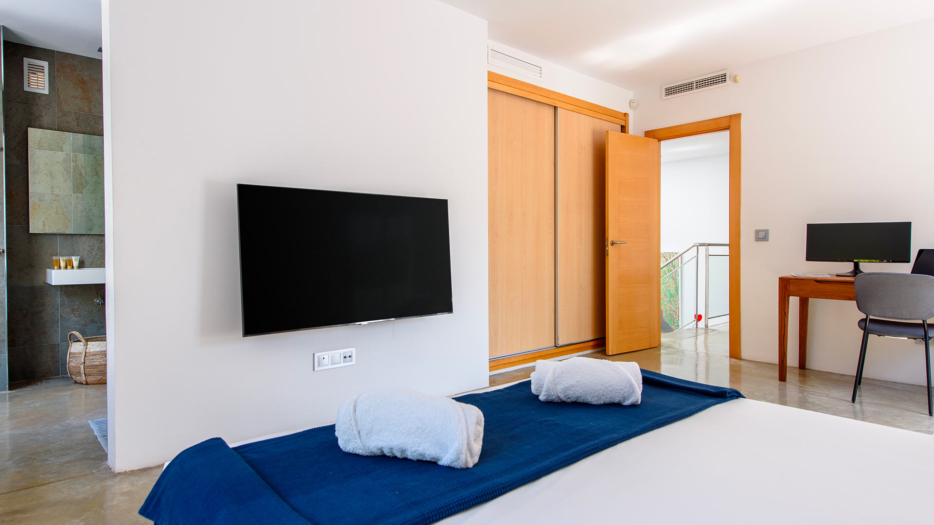 Large TV and ensuite in one of the bedrooms at Villa Fabrik in Ibiza