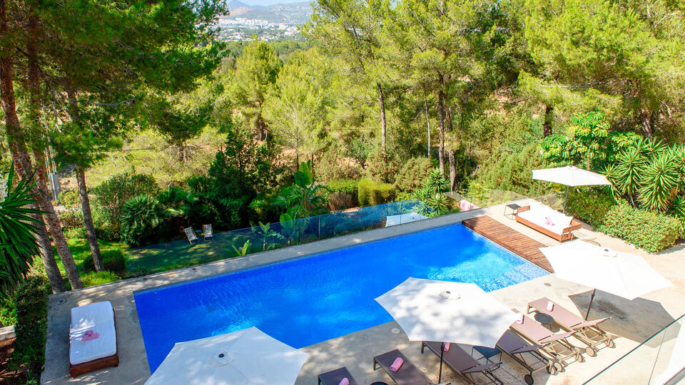 View of the pool at Villa Fabrik in Ibiza and the luscious surroundings