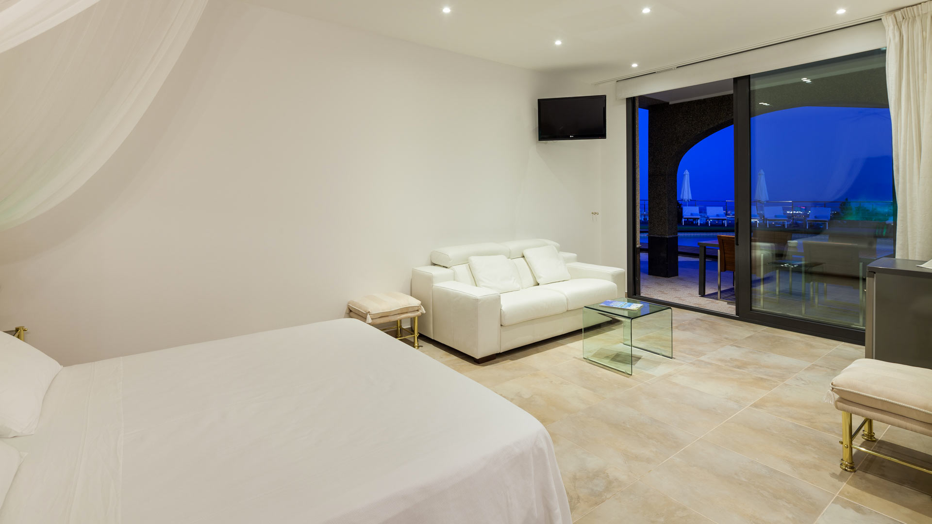 One of the bedrooms at night and the view from the patio doors at Villa Fountain Ibiza