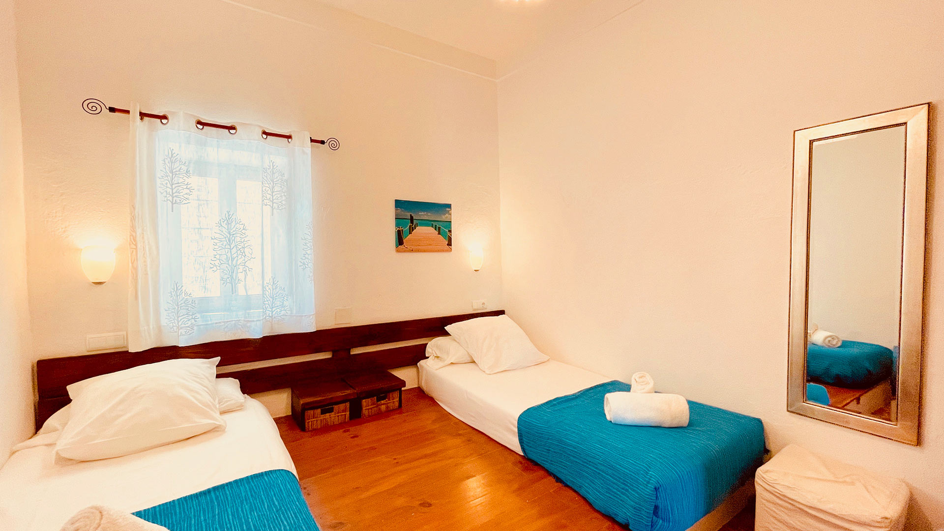 Twin bedroom in Villa Torre Pau with blue and white linens