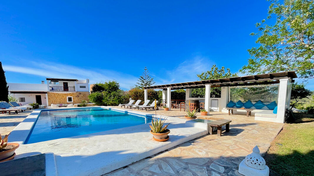 Villa Torre Pau's large swimming pool with sunloungers surrounding it in Ibiza