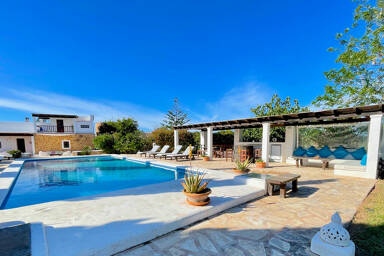 Villa Torre Pau's large swimming pool with sunloungers surrounding it in Ibiza