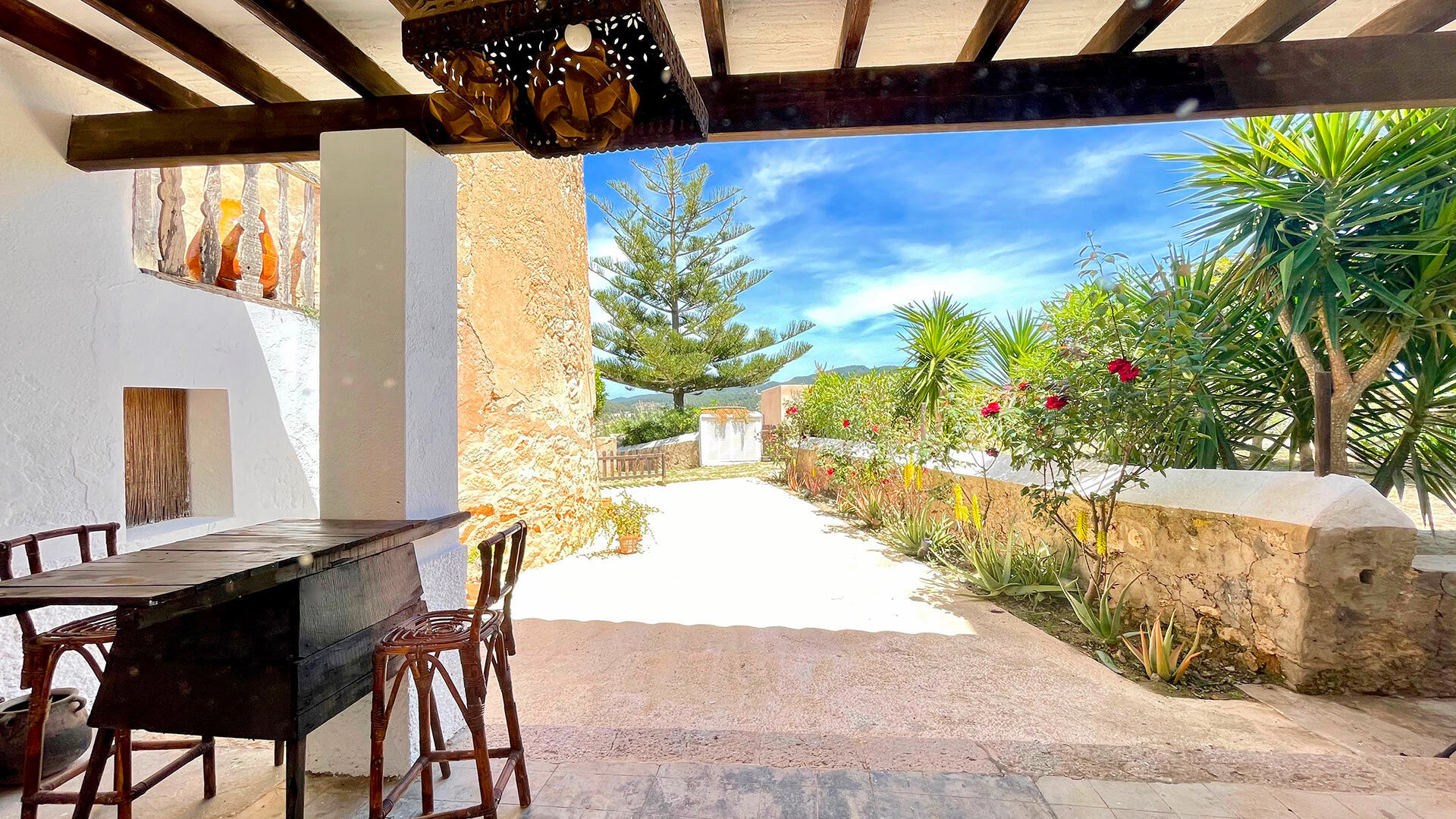 View from under the pergola and the beautiful tiled walkway to the swimming pool at Villa Torre Pau in Ibiza