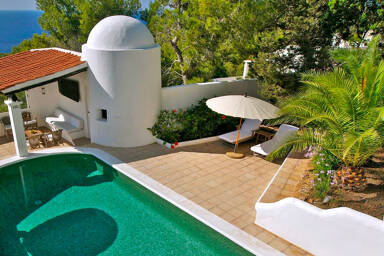 View from one of the higher parts of Villa Trillo in Ibiza and the green hued swimming pool