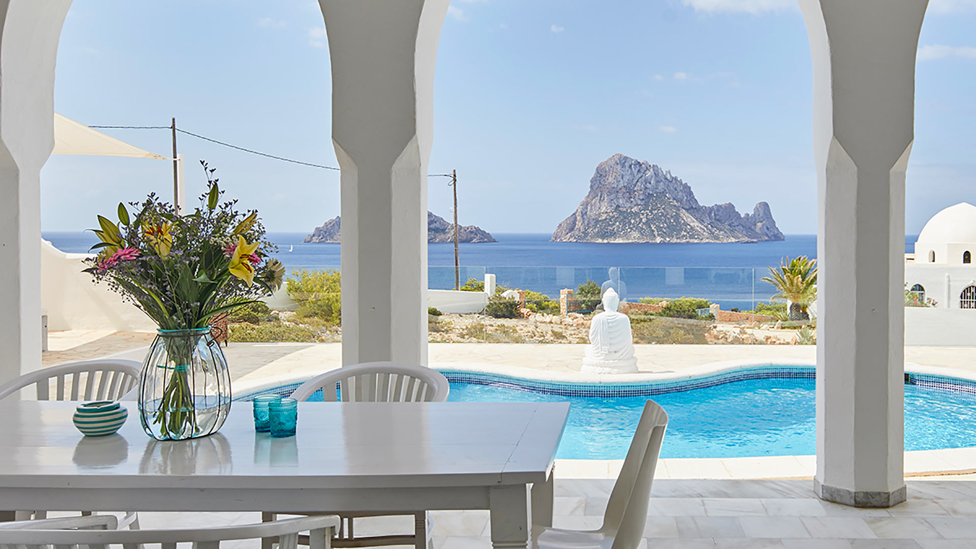 View from over the covered outdoor dining area with swimming pool views at Villa Arabian in Ibiza