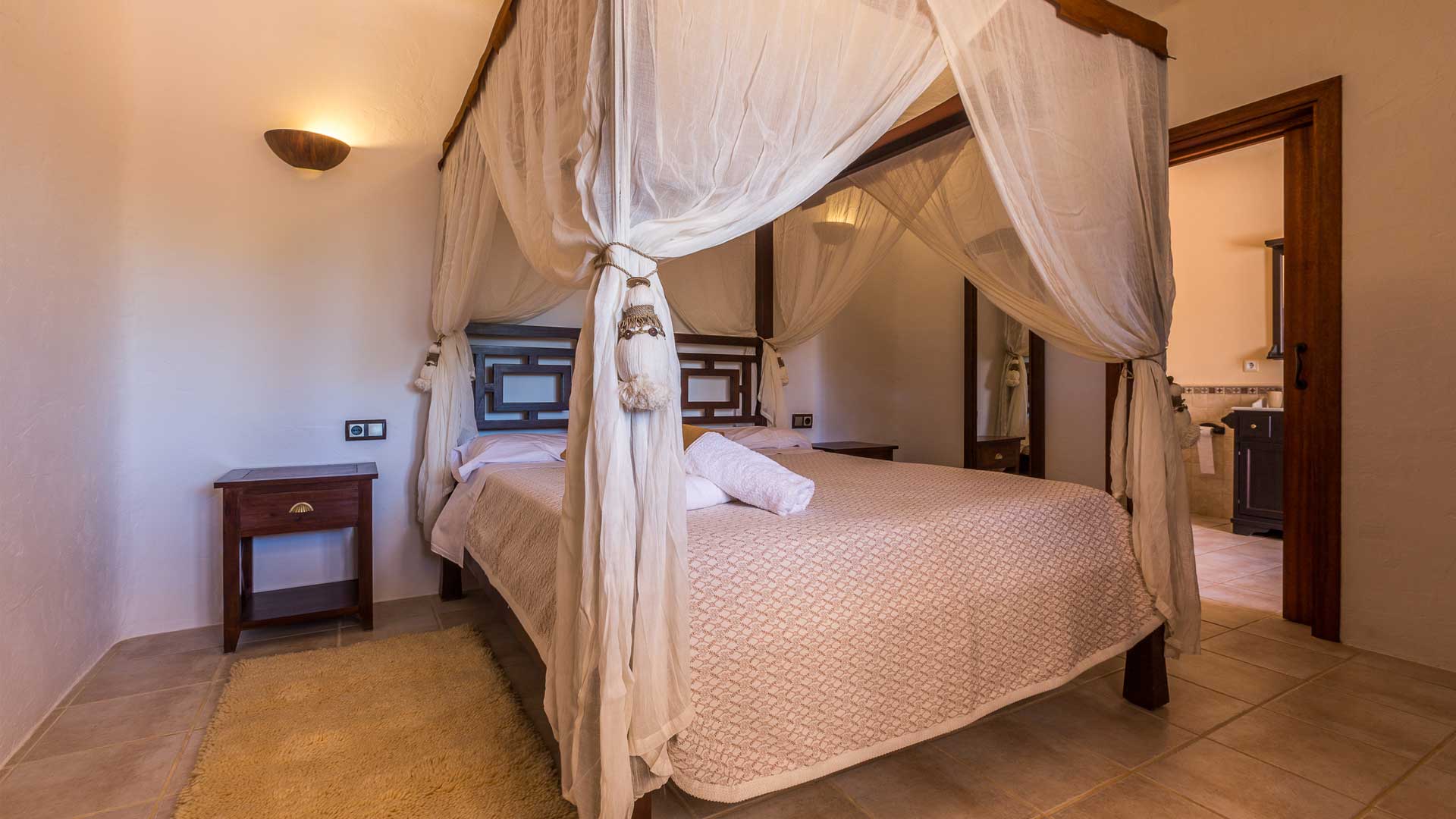 One of the bedrooms at Villa Es Canar in Ibiza with a grand canopy bed