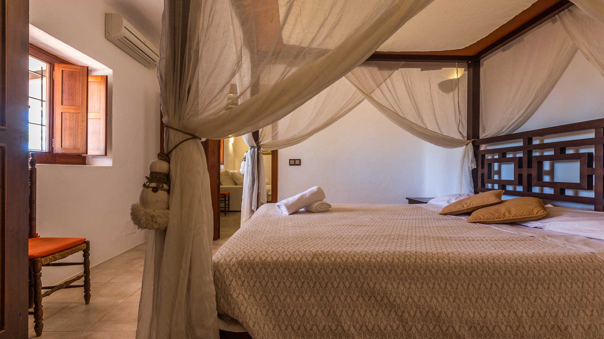 A large bedroom in Villa Es Canar in Ibiza with a canopy bed and light features