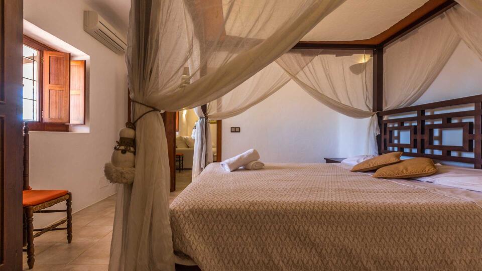 A large bedroom in Villa Es Canar in Ibiza with a canopy bed and light features