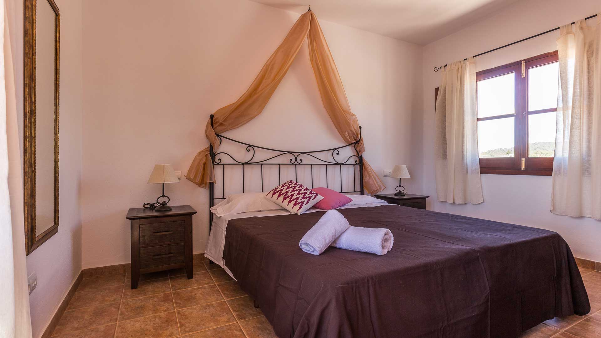 Large bedroom in Villa Es Canar in Ibiza with a large window to let the sunlight in
