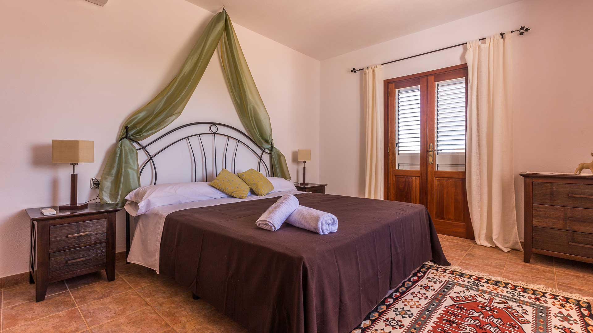 Patio doors in a large bedroom at Villa Es Canar in Ibiza to the outside