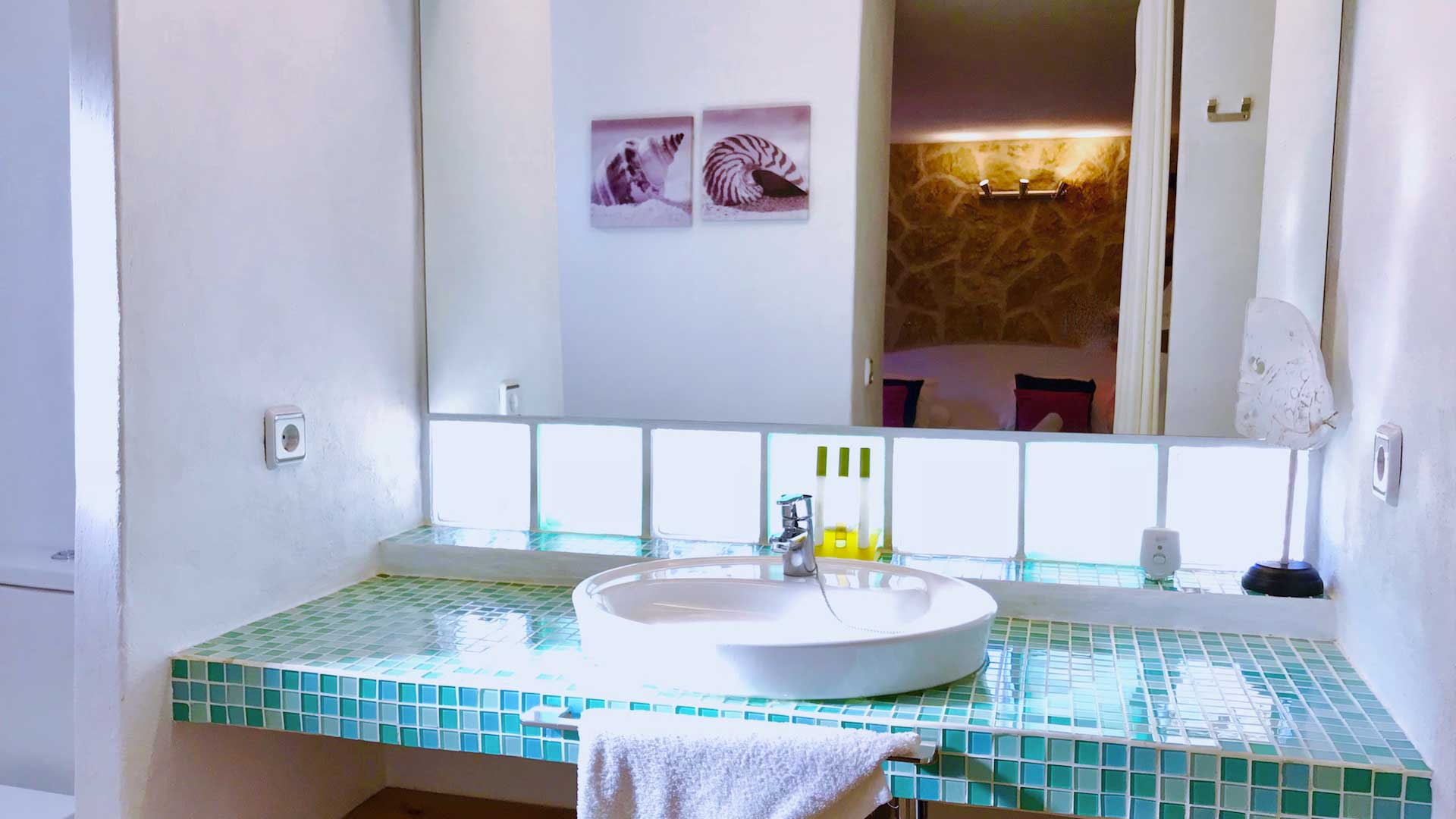 Bathroom with large mirror and beautiful light tile pattern in Villa Garroba in Ibiza