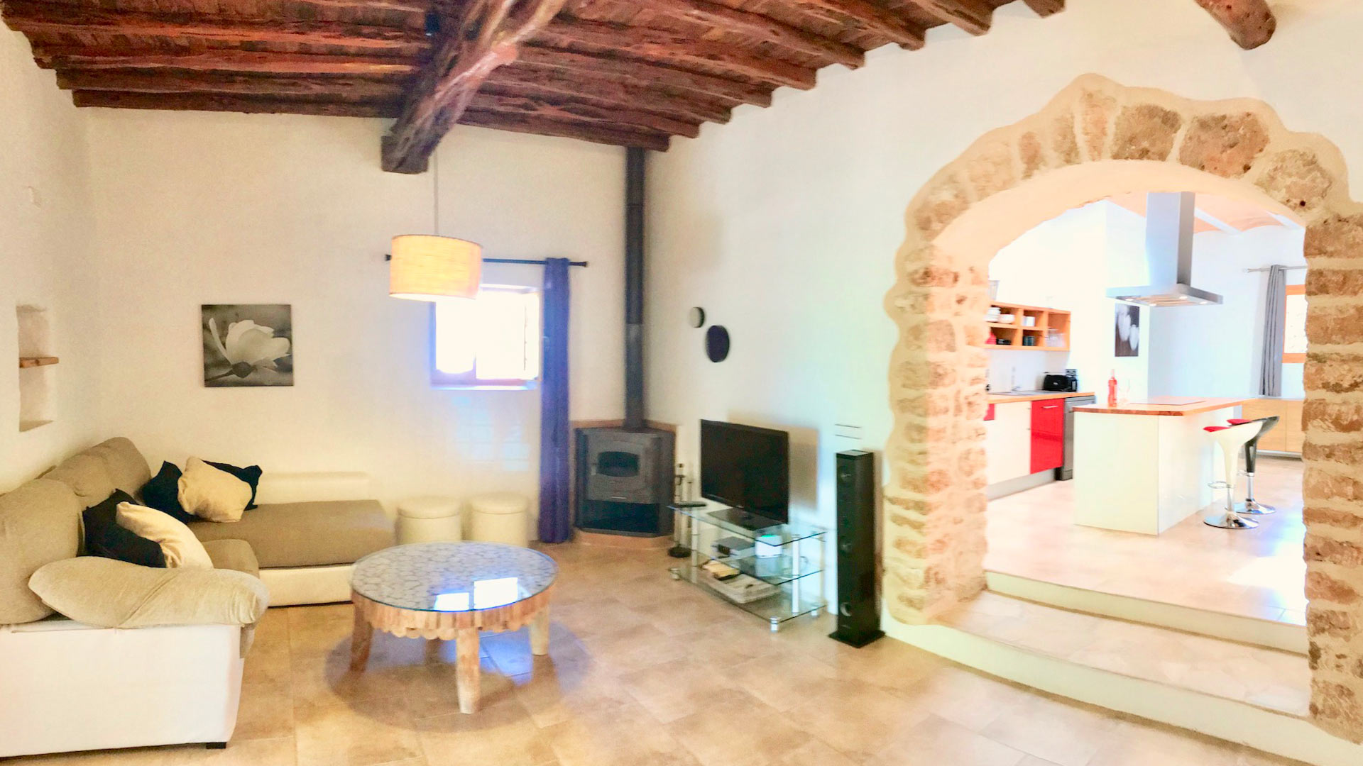 Living space in with small fireplace, wooden ceilings in Villa Garroba in Ibiza