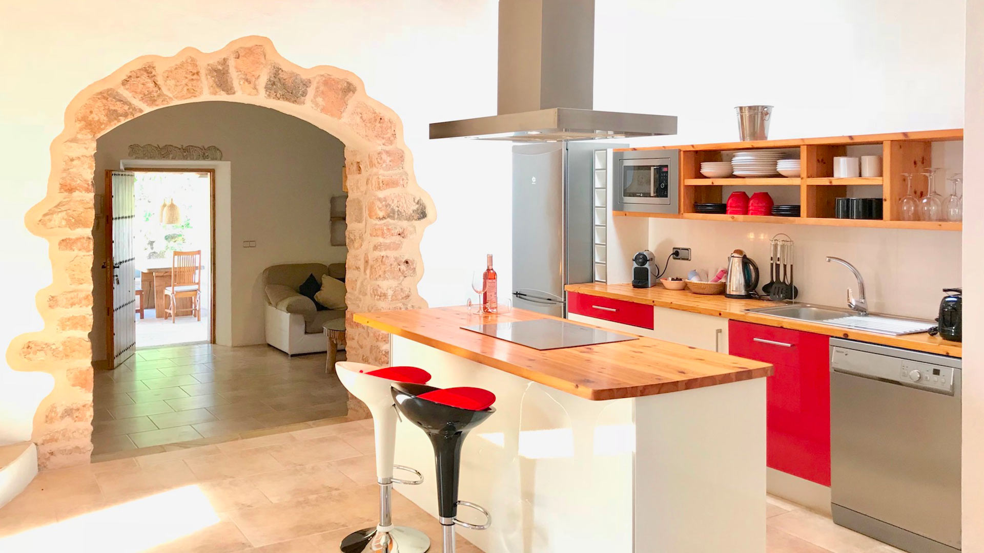 Beautiful kitchen in Villa Garroba in Ibiza with red accents and modern appliances