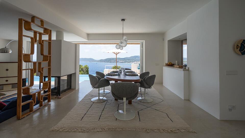 Dining room at Villa Orizonia in Ibiza with large patio doors looking at the pool and Sea