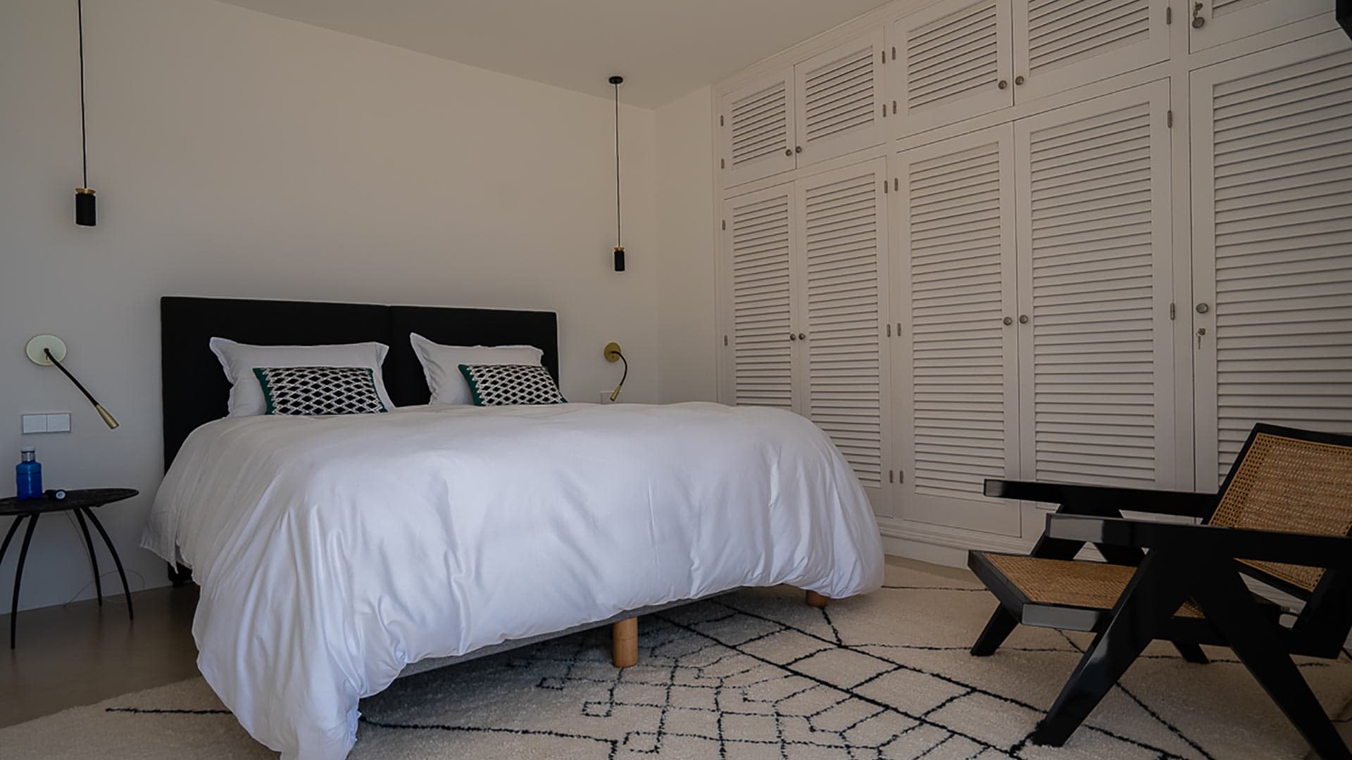 One of the bedrooms at Villa Orizonia in Ibiza with large white bed and wardrobes