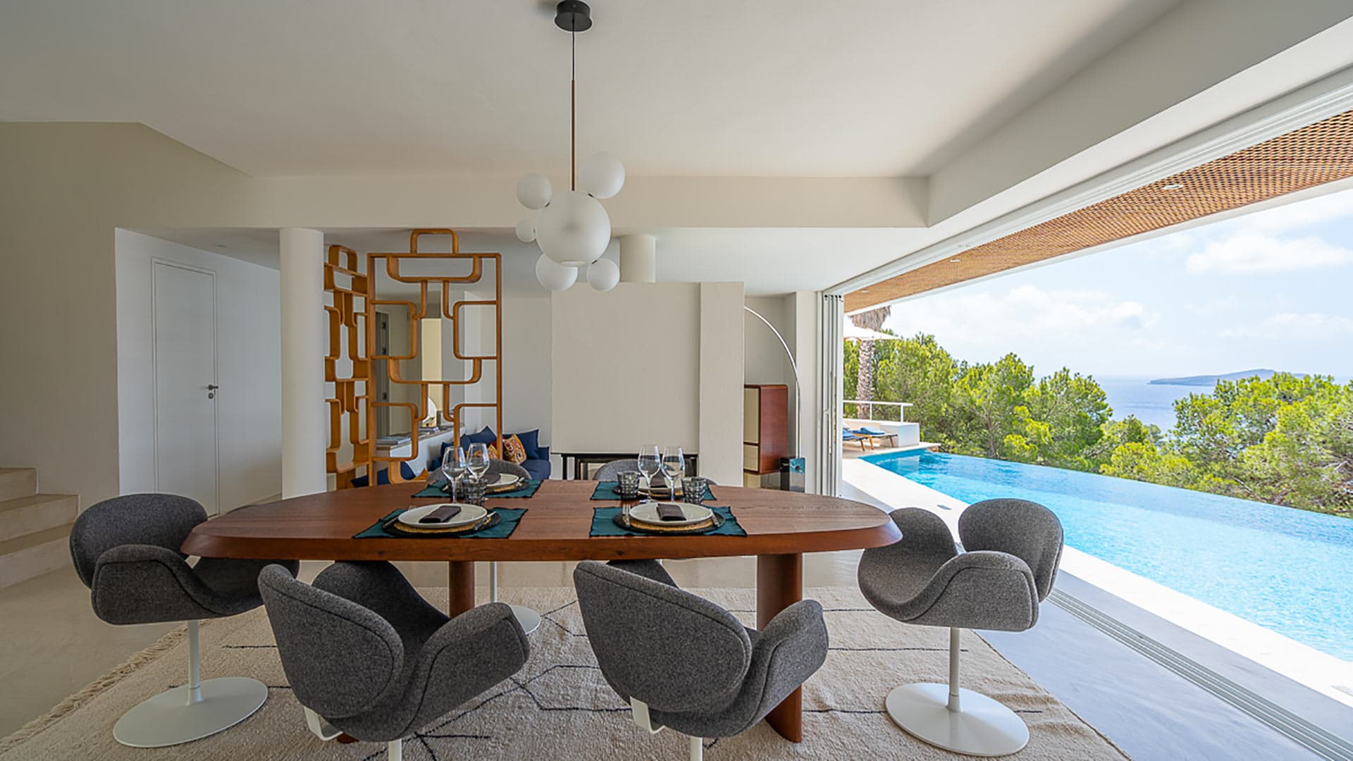 Opened French doors in the dining rooms of Villa Orizonia with views of the infinity pool