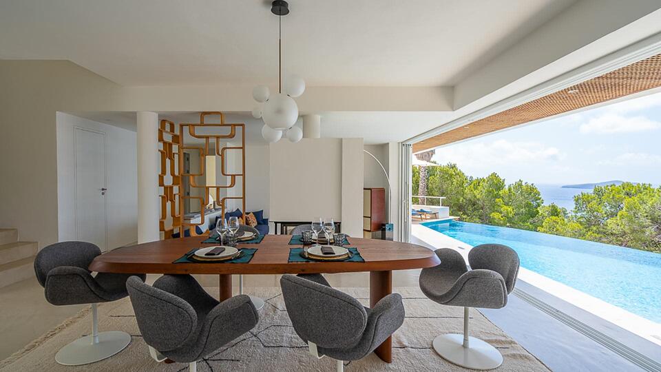 Opened French doors in the dining rooms of Villa Orizonia with views of the infinity pool